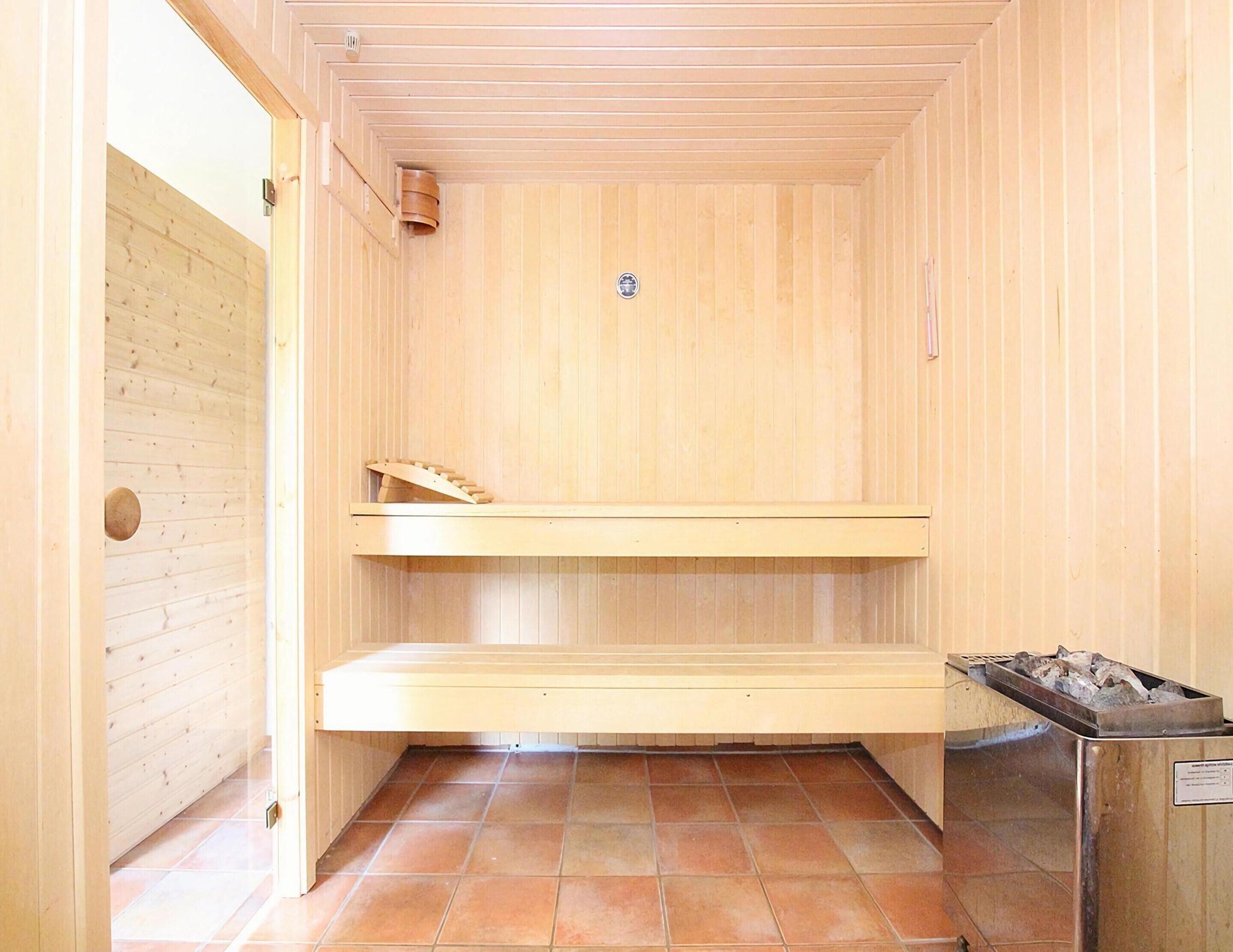 Een sauna met houten wanden en een betegelde vloer.