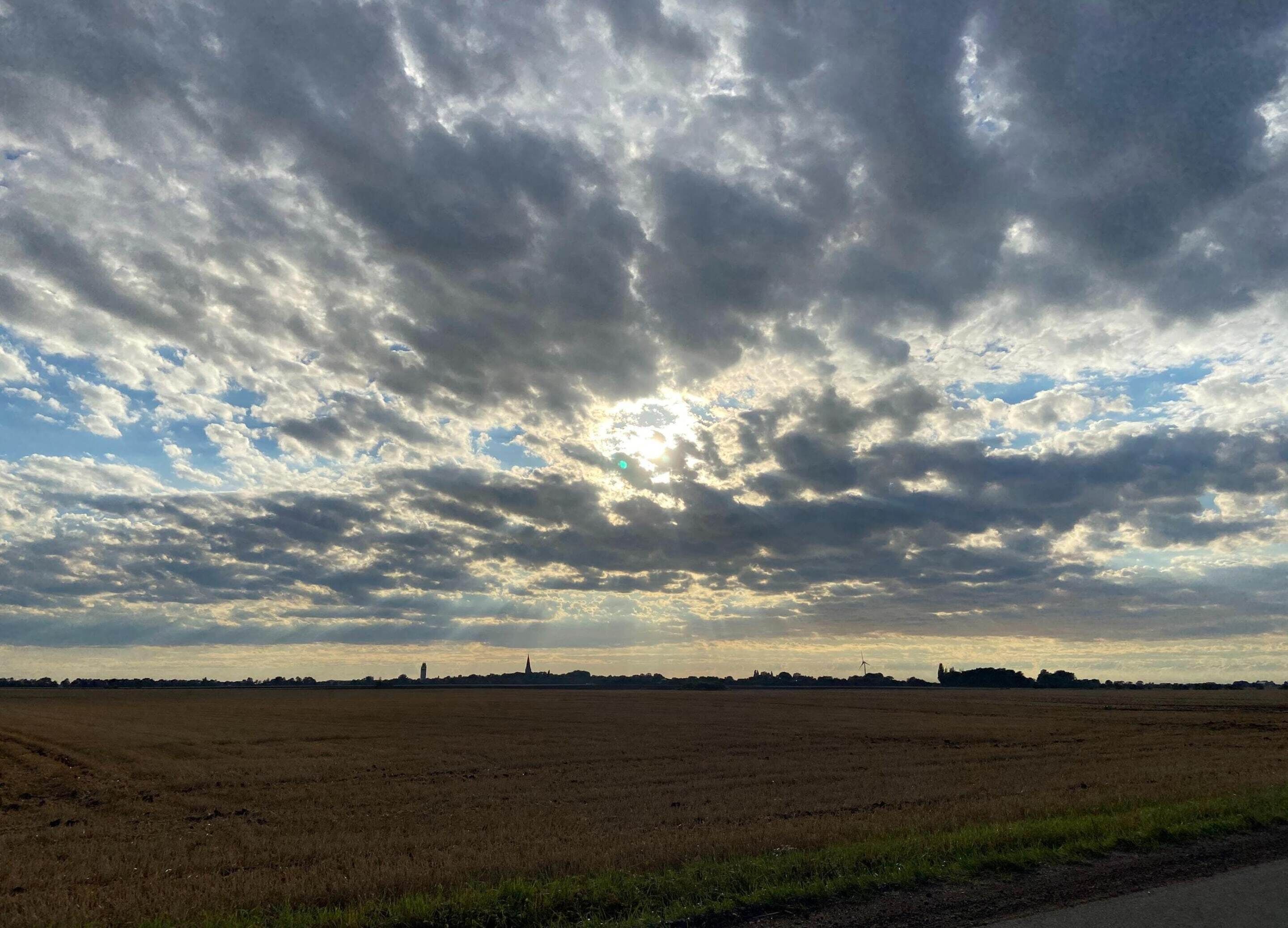 A wide, open field with a cloudy sky.