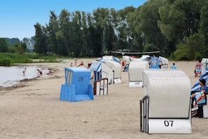 Beach huts numbered 35, 43, 07, and 08 with a volleyball net in the background. - Ferienhaus Haffschein, Moenkebude (Monkebude)