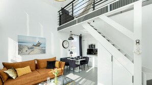 A modern living room with a sofa, coffee table, and artwork on the wall. - Holiday Home With Whirlpool Bathtub, Wrzosowo (Kamien Pomorski)