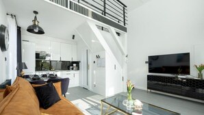 A modern living room with a sofa, coffee table, and a TV on a black cabinet. - Holiday Home With Whirlpool Bathtub, Wrzosowo (Kamien Pomorski)