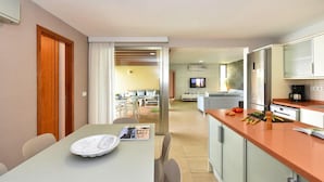 A modern kitchen with a dining area, a TV, and a living space. - Holiday Home, Maspalomas (San Bartolomé de Tirajana)