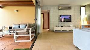 A modern living room with a sofa, coffee table, TV, and a white console. - Holiday Home, Maspalomas (San Bartolomé de Tirajana)