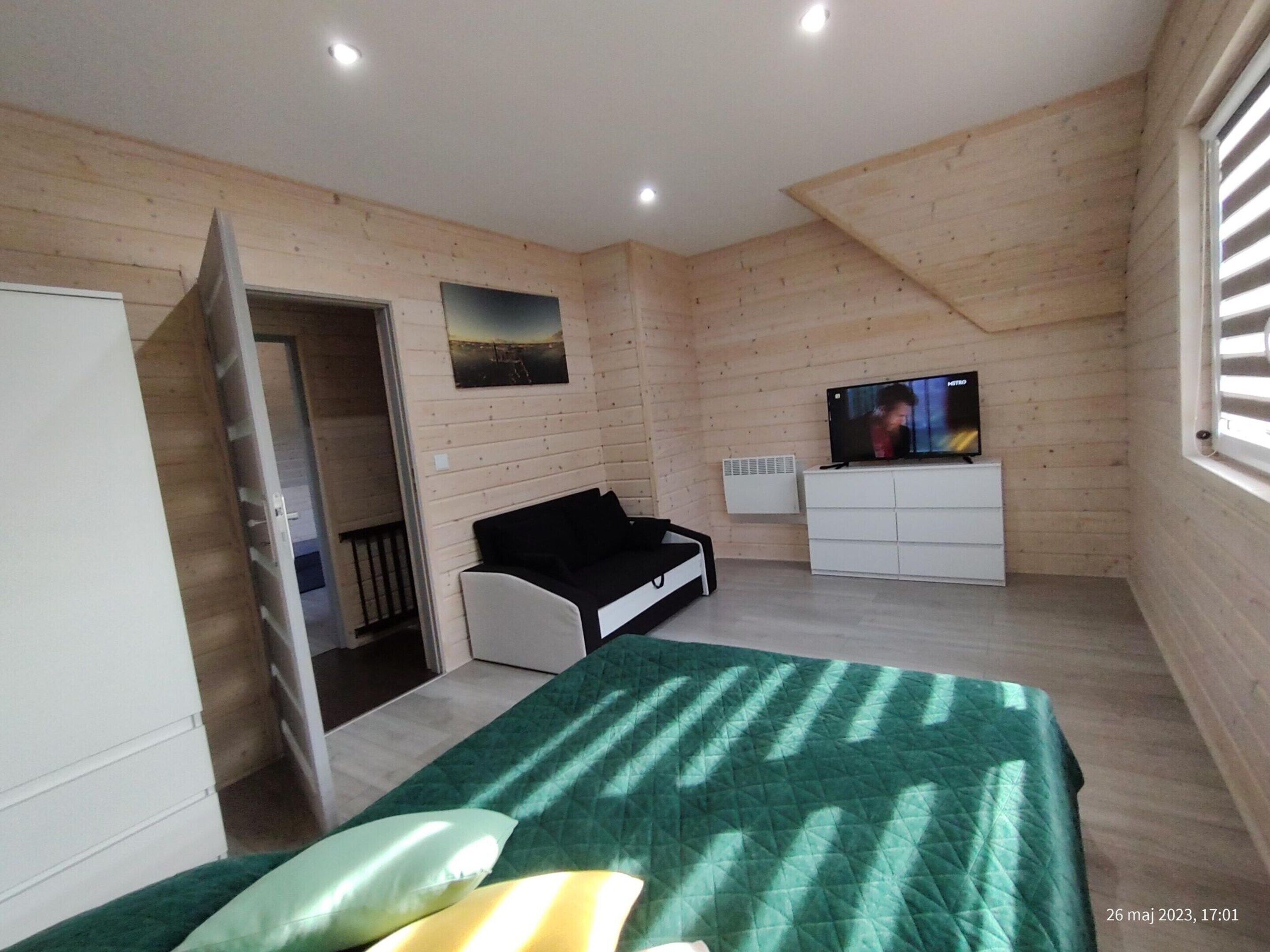 Ein Schlafzimmer mit einem Bett, einem Fernseher, einem Kleiderschrank und einem Fenster.