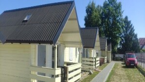 A row of white cabins with sloped roofs, each with a small porch and a window. - Holiday Homes Close to the Seaside Beach (Ustronie Morskie)