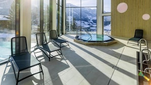 A modern indoor pool area with clear views of snowy mountains through large windows. - Apartment in Matrei in Osttirol With a Garage (Matrei in Osttirol)