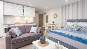 Une chambre moderne équipée d’un lit, d’un canapé, d’une table à manger et d’un coin cuisine.
