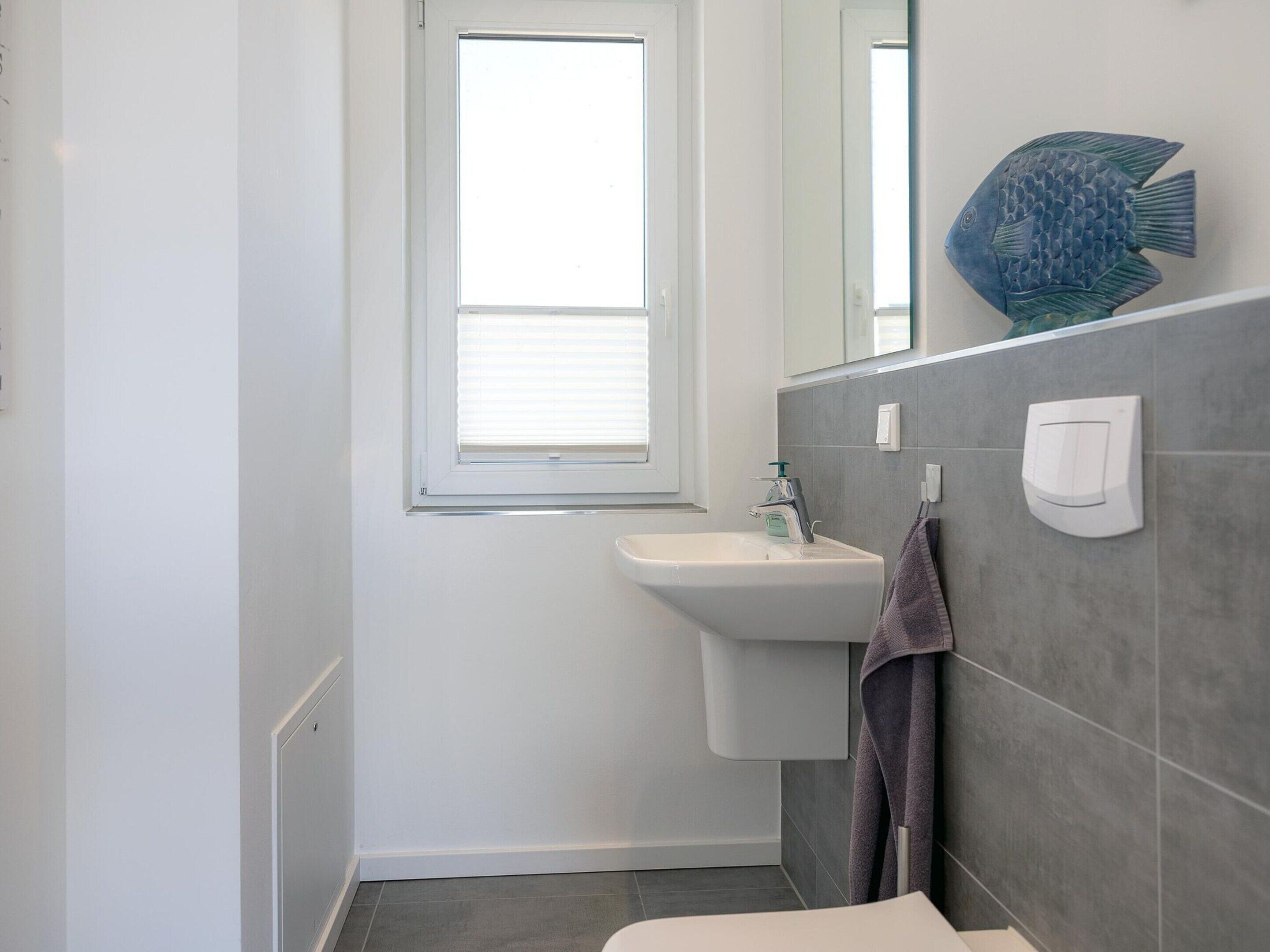 A bathroom with a window, a sink, and a towel rack.