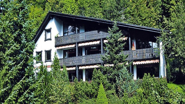 A multi-story building with balconies, surrounded by lush greenery and rocks. - Ferienwohnung im Haus Schiefertal, Wieda (Walkenried)