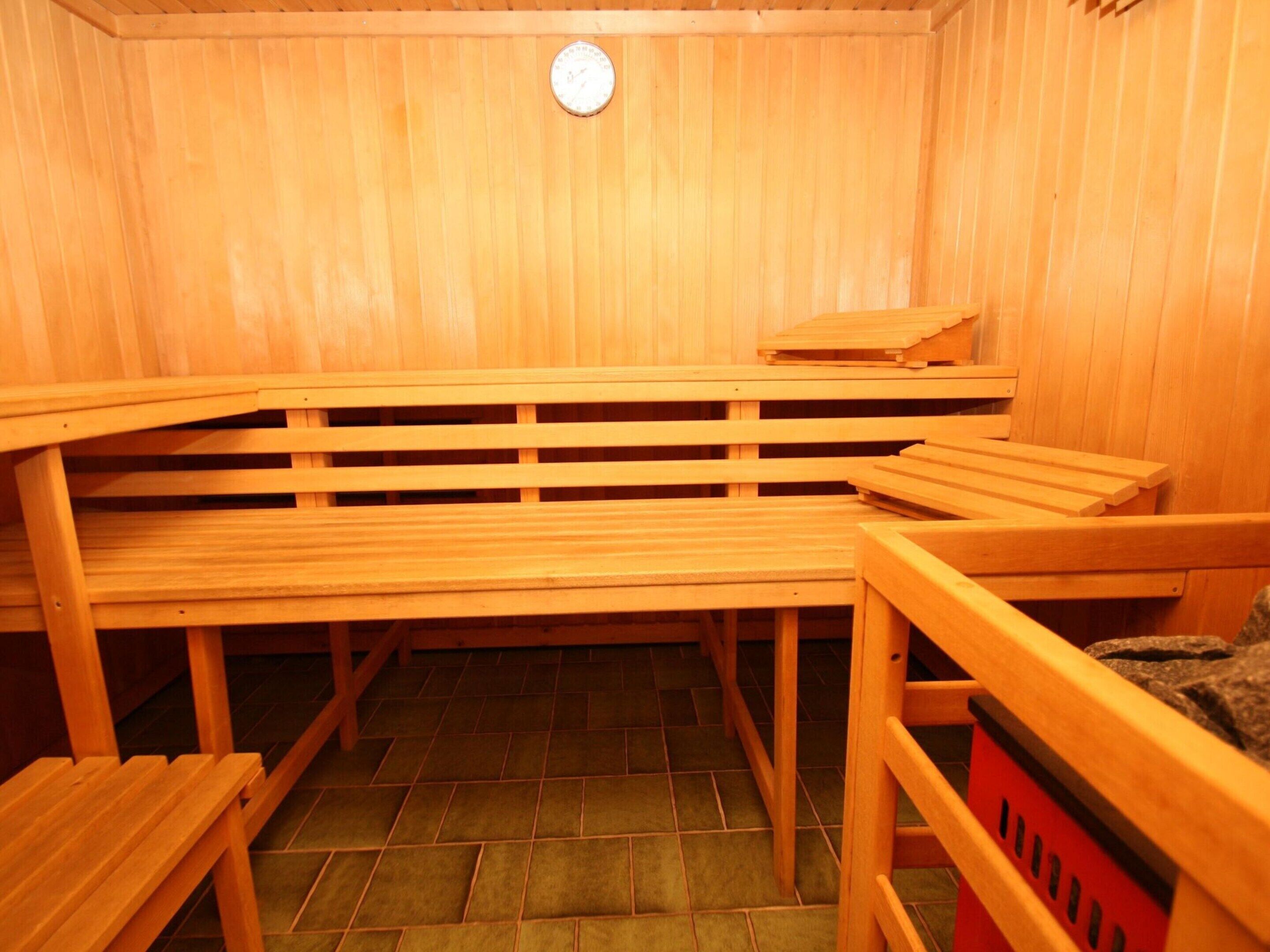 Een sauna met houten banken en een betegelde vloer.