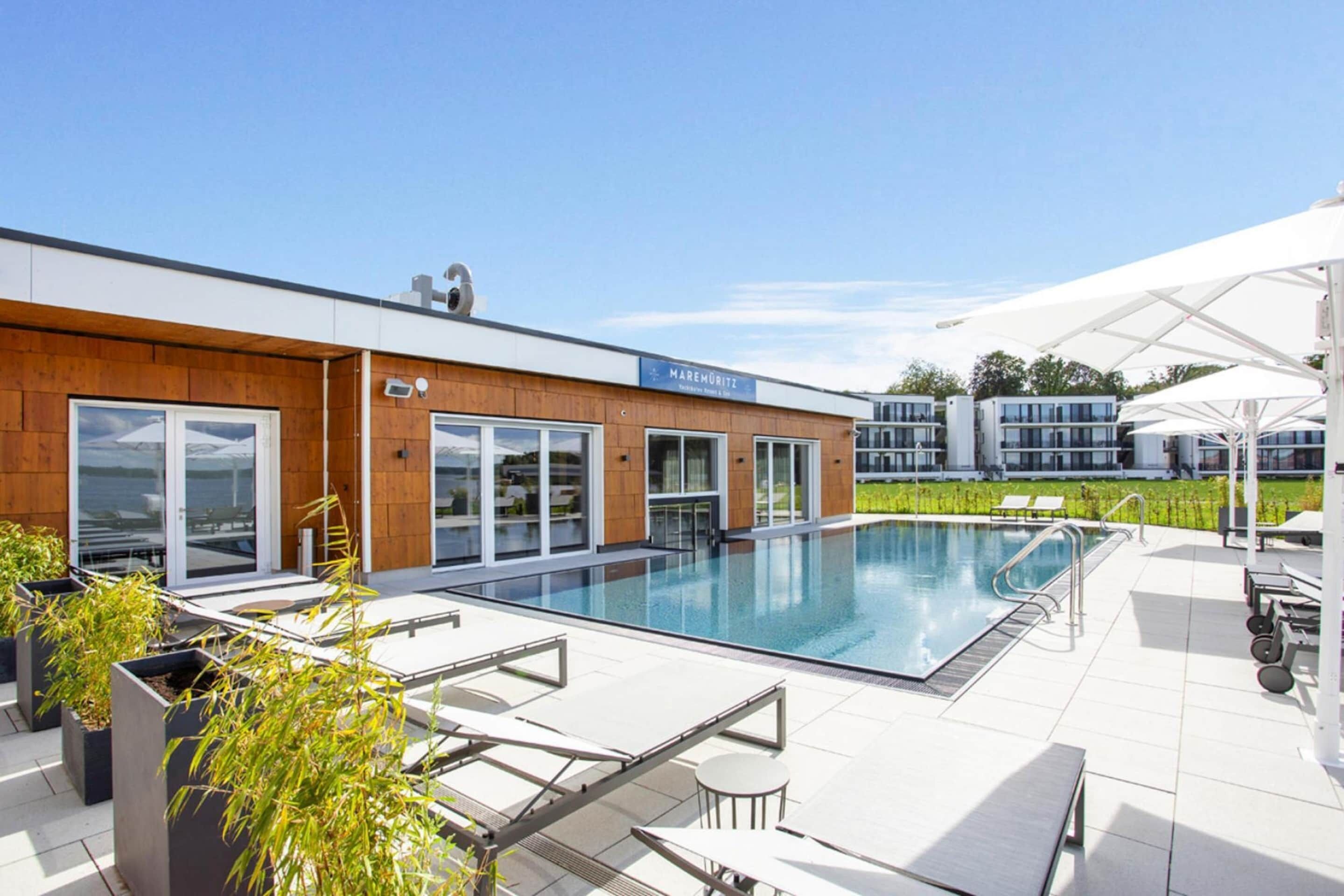 A modern hotel with a pool area, outdoor seating, and a sign reading "MAREMORITZ".