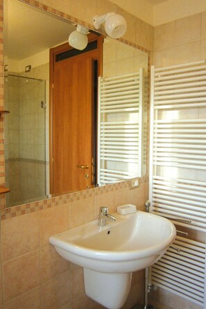 A bathroom with a sink, mirror, and towel rack. - Apartment in Lazise With Parking Space (Lazise)