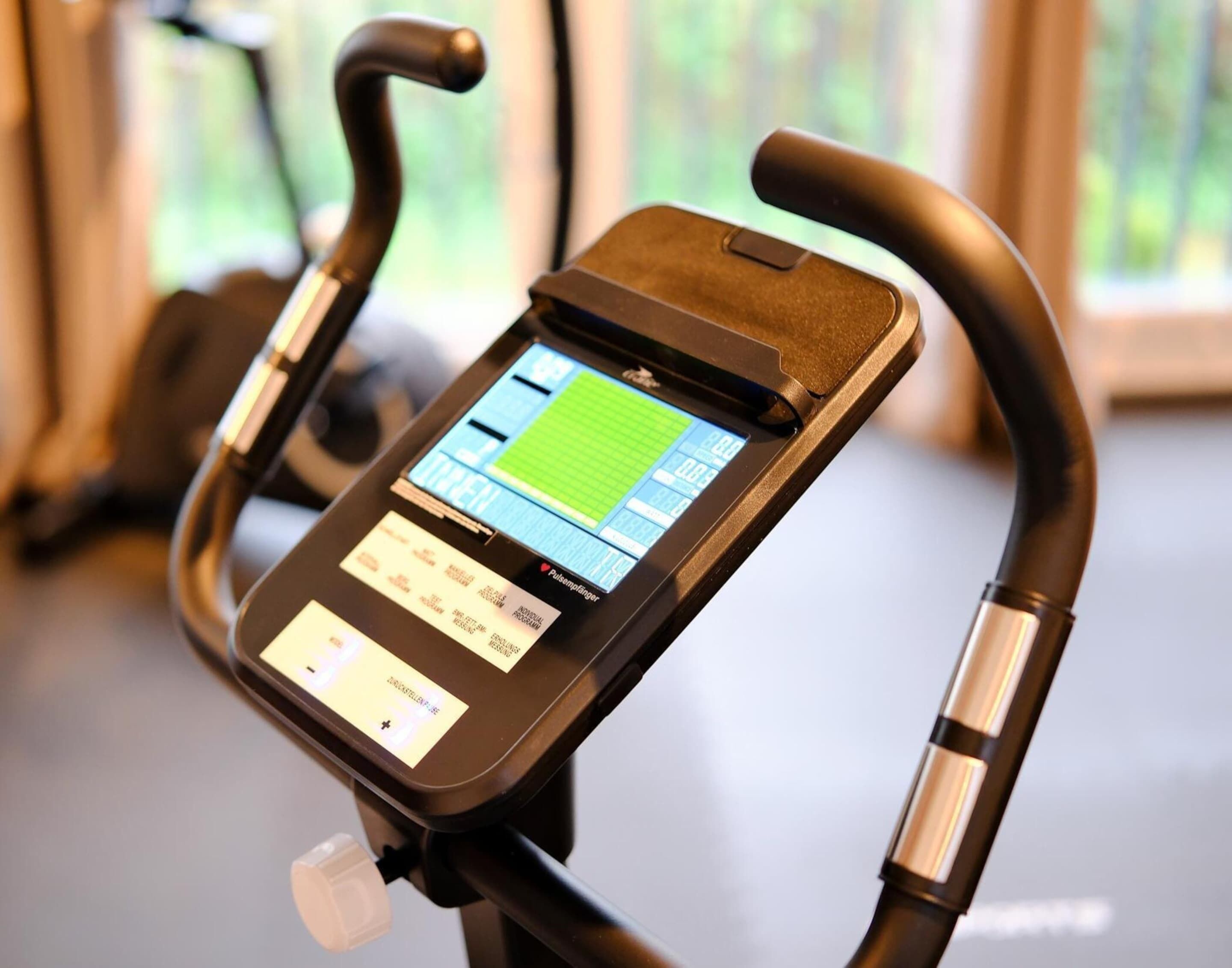 A stationary bike with a digital display and a handlebar.
