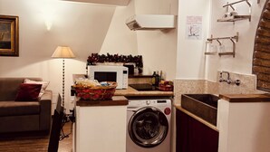 A compact kitchen with a washing machine, a microwave, and a sink. - Loft Apartment Termini Colosseum (Roma)