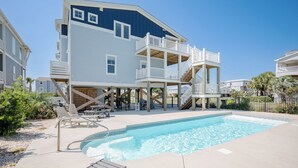 A multi-story building with a pool, outdoor seating, and a wooden deck. - A New Hope: Ocean View with Private Pool and Easy Beach Access (Oak Island)