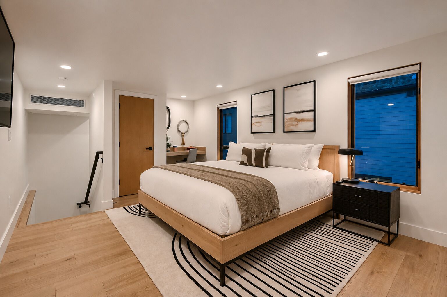 Un dormitorio moderno con cama, mesita de noche y un ventanal amplio.