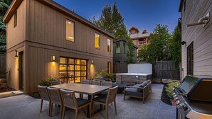A modern patio with a dining table and chairs, a barbecue grill, and a hot tub. - 1060 Park Ski Magnificent Mountain Retreat 5 Bedroom Home by RedAwning (Park City)