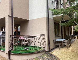 A courtyard with a covered seating area, a small table, and chairs. - Apartment in Pobierowo Near Baltic Sea Beach (Rewal)