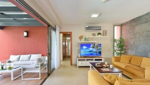 Una sala de estar moderna con un sofá, una mesa de centro y una televisión.