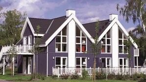 A two-story house with a white balcony and a dark roof. - Appartements im Schlosspark Bad Saarow (Bad Saarow)
