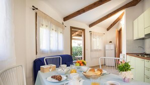 A breakfast setup with a table, breakfast items, and a view of the outside. - Bungalow in Riotorto Near sea Beach (Piombino)