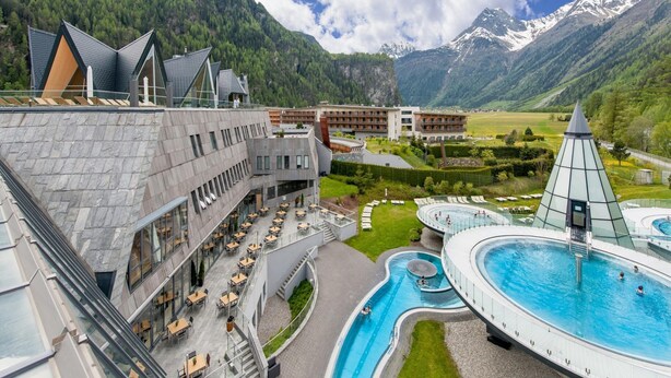 A hotel with a pool, outdoor seating, and mountain views. - Apartment and Terrace in Langenfeld (Laengenfeld)