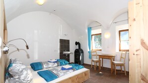 A cozy room with a bed, a sink, a heater, and a window with curtains. - Apartment and Terrace in Langenfeld (Laengenfeld)