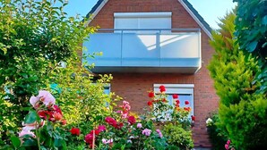 A two-story house with a brick facade, a small balcony, and a window with shutters. - Ferienwohnung im Appartementhaus Stapel, Busum (Büsum)