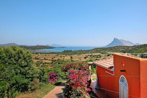 Overlooking a serene coastal landscape, this Mediterranean-style building offers a tranquil retreat with a balcony.