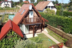 A residential property with a sloped roof, a wooden balcony, and a fenced yard. - Holiday Home, Kolczewo (gmina Wolin)