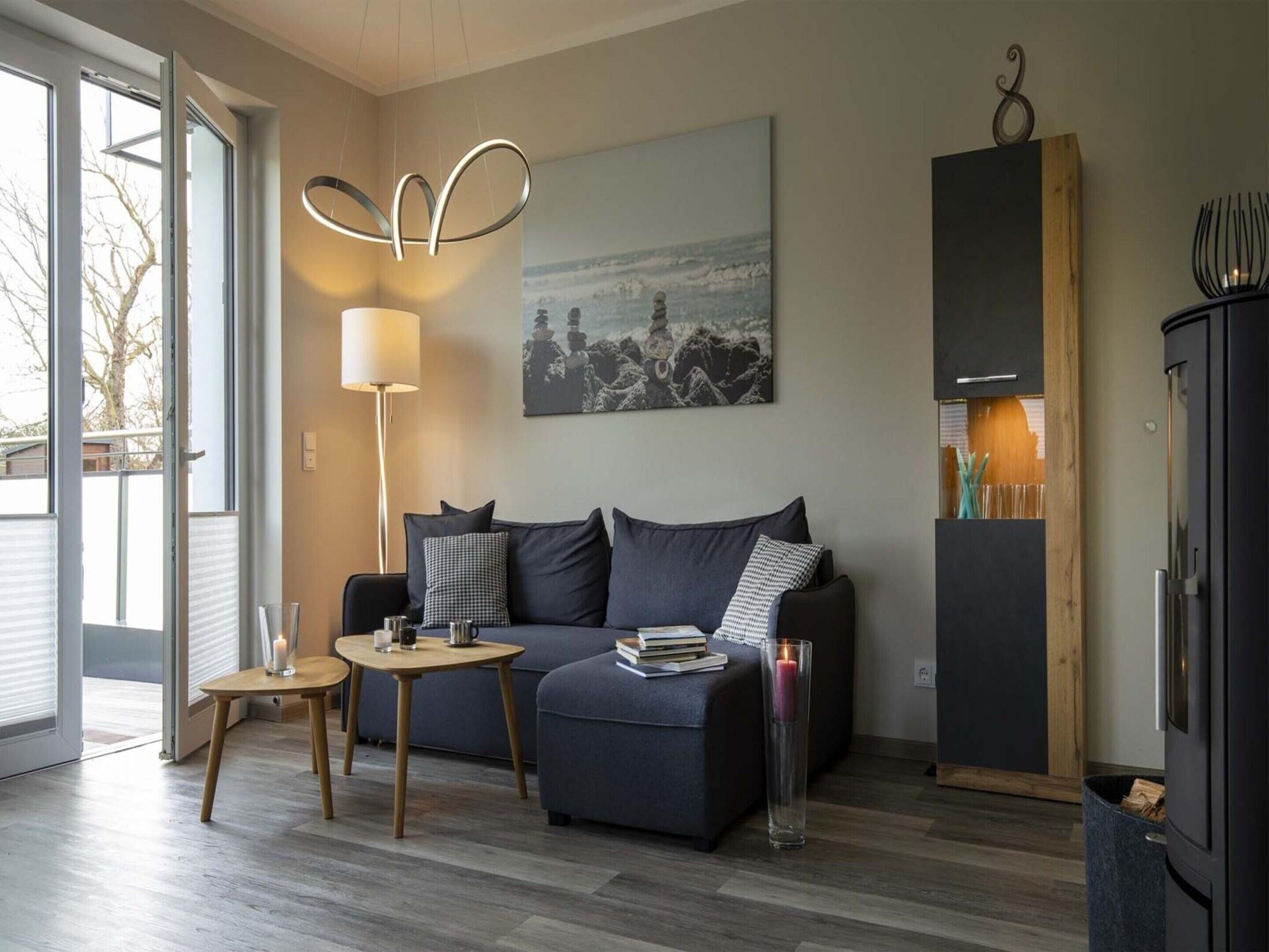 A modern living room with a sofa, a small table, a floor lamp, a painting, and a cabinet.