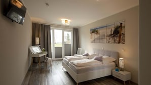Ein modernes Schlafzimmer mit einem großen Bett, einem Schreibtisch und einem Bild an der Wand.