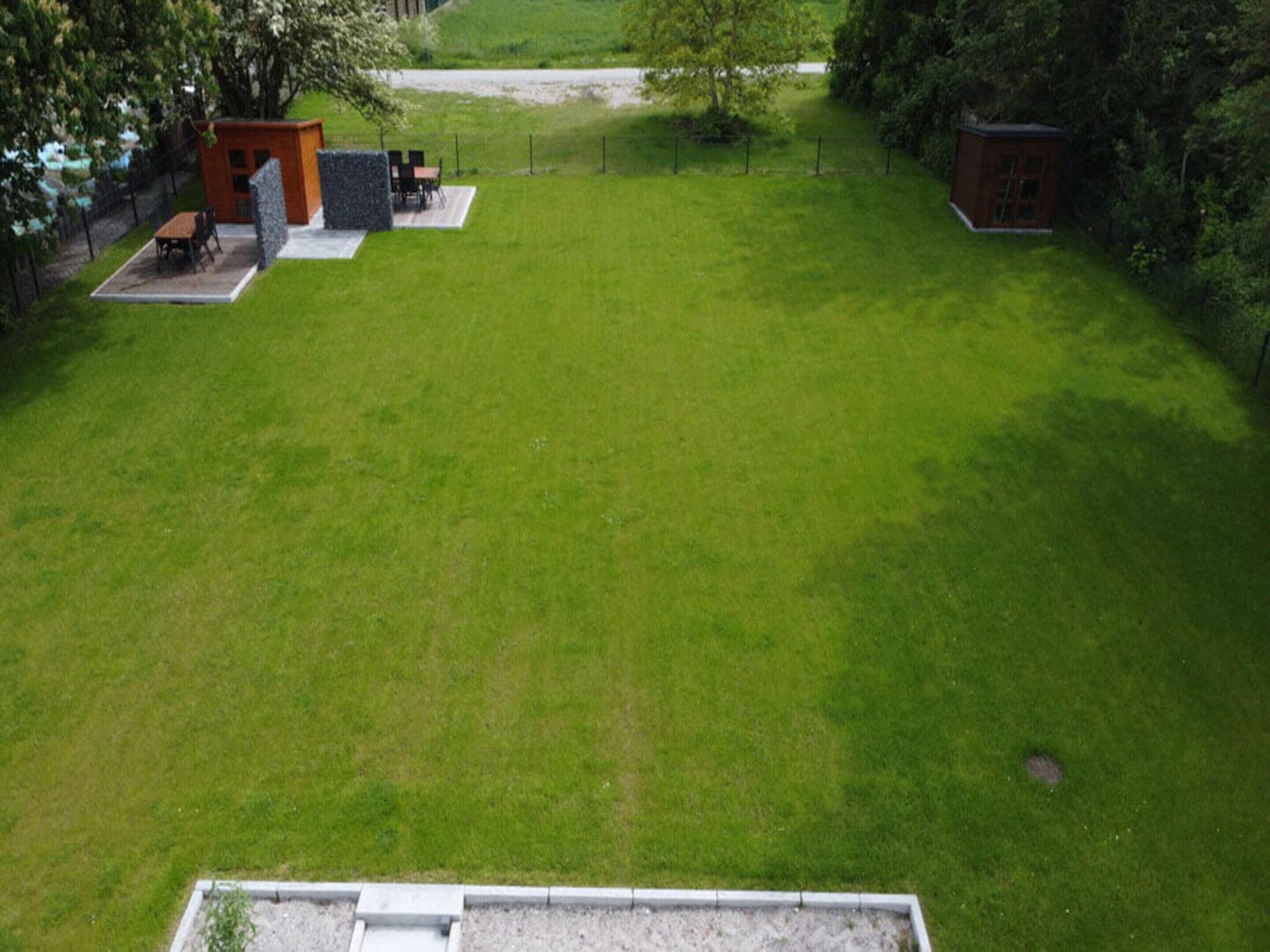 A spacious backyard with a patio area, a small shed, and a well-maintained lawn.
