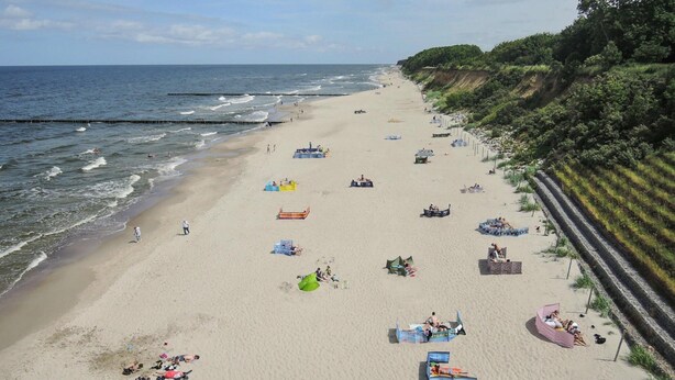 Une plage avec des tentes, des chaises longues et des gens qui se détendent.