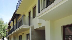 Un immeuble résidentiel à plusieurs étages, doté de balcons, de fenêtres et d’une porte bien visible.