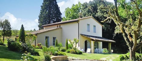 A two-story building with a garden in front.