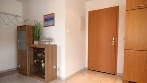 A room with a wooden cabinet, a door, and a small plant on a shelf. - Appartementhaus Nicole, Zinnowitz (Zinnowitz)