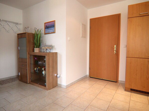 A room with a wooden cabinet, a door, and a small plant on a shelf.