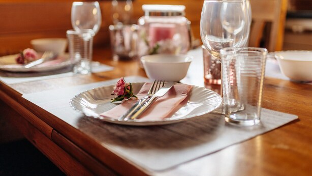 A dining table set with plates, cutlery, glasses, and a vase with a flower. - Blockhouse in the Fuchsbau, Bad Sachsa (Bad Sachsa)