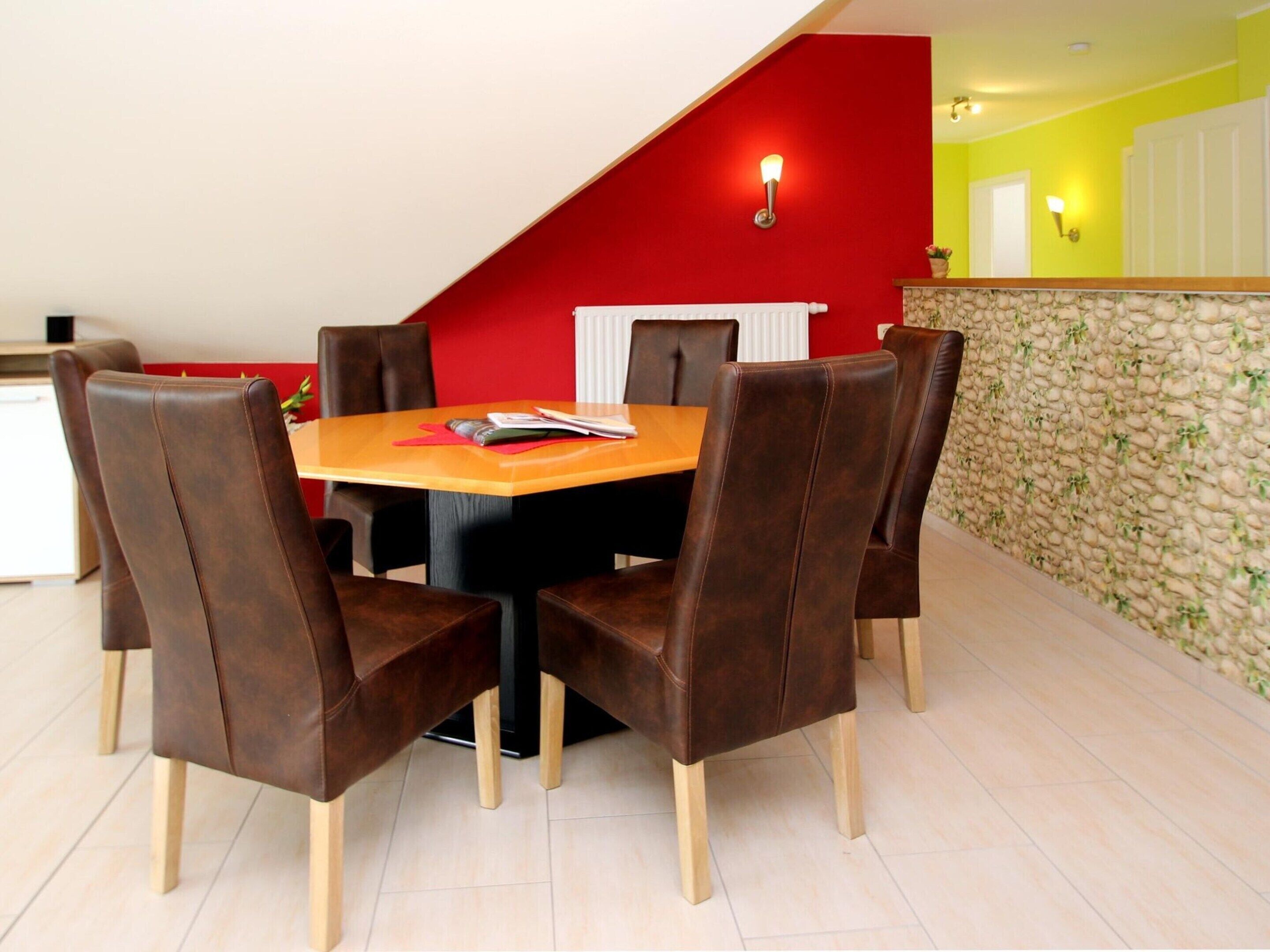Un coin repas avec une table en bois et six chaises marron.
