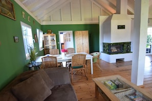 A dining area with a white table, wicker chairs, and a green wall. - House With Private Beach by the Lake, Whirlpool (Gniewino)