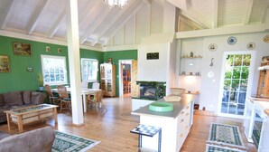 Un vaste espace de vie comprenant une cuisine, un plancher en bois et un coin repas avec des chaises et une table.
