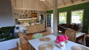 Une cuisine spacieuse dotée d’un îlot central, un coin repas avec une table et des chaises, et un salon confortable avec un canapé.