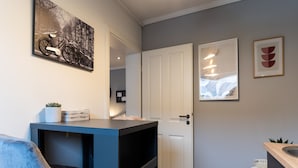 A modern kitchen with a blue countertop, a white door, and a small white table. - Ferienwohnung in Tonning (Toenning)