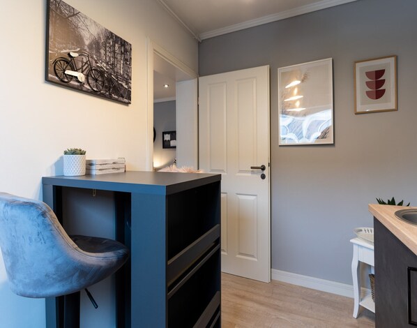 A modern kitchen with a blue countertop, a white door, and a small white table. - Ferienwohnung in Tonning (Toenning)
