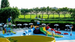 A water park with slides and a large yellow pool.