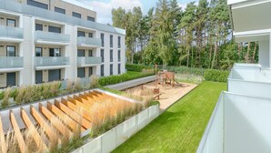 A modern apartment complex with a central courtyard featuring a playground and a grassy area. - Apartment in Rewal Near Baltic Sea Beach (Rewal)