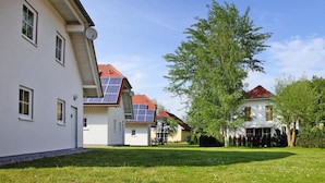 A residential area with white houses, red roofs, and solar panels. - Ferienhauser am Kummerower See, Verchen (Verchen)