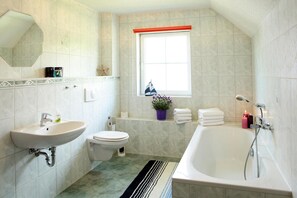 A bathroom with a sink, toilet, and bathtub. - Ferienhauser am Kummerower See, Verchen (Verchen)