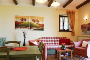 Un salon avec un canapé, une table et deux tableaux accrochés au mur.